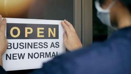 person putting open sign on door